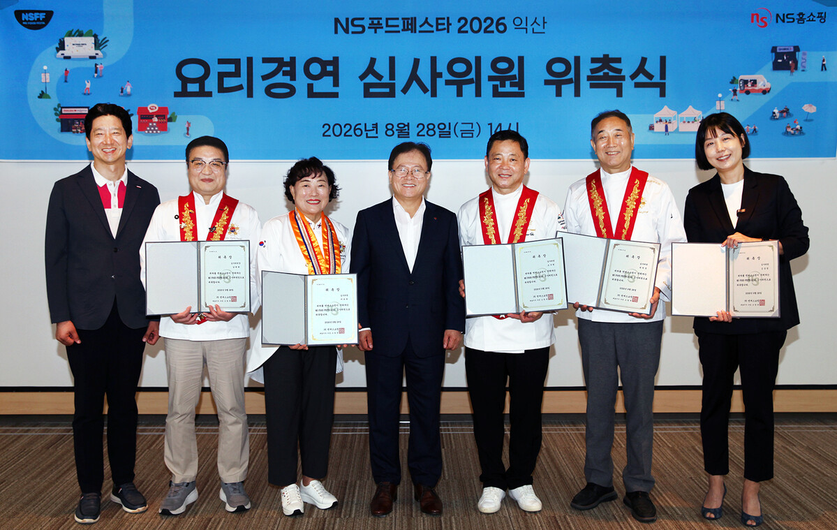 △NS홈쇼핑이 지난 28일 ‘NS푸드페스타 2026 익산’의 요리경연 부문 심사를 이끌 심사위원을 공식 위촉했다.왼쪽부터 (NS홈쇼핑 미디어전략본부 허영환 이사, 남대현 명장, 이순옥 조리기능장, NS홈쇼핑 조항목 대표이사, 조우현 명장, 천덕상 명장, 김상영 요리연구가)
